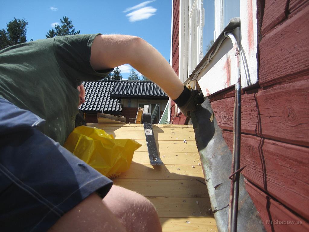 IX70_1467.JPG - M försöker få fason på taket över farstukvisten, eller rättare sagt kollar hur vi skall vika upp nya takpappen..